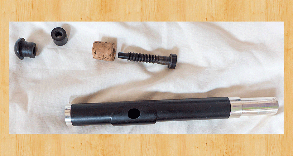 A deconstructed adjustable screw cork on a wooden headjoint made from African Blackwood.